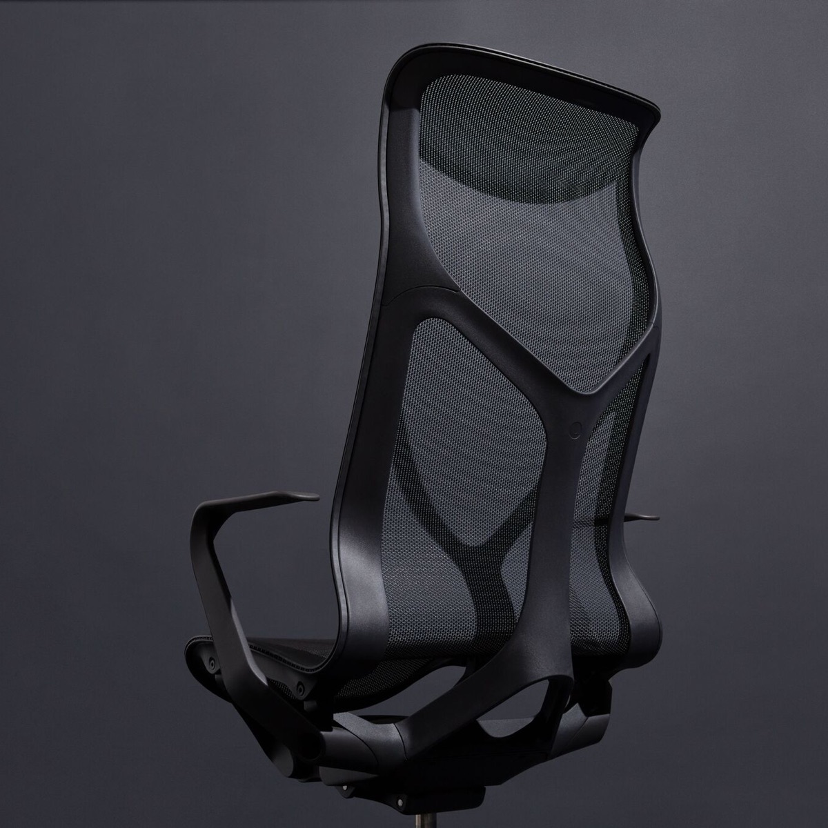 Una silla de escritorio Cosm con respaldo alto Graphite gris oscuro con brazos fijos sobre un fondo gris oscuro.
